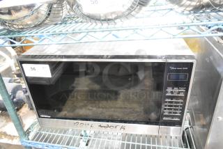 The Genius Stainless Steel Countertop Microwave Oven, 120V, marked "Doesn't Work", on shelving. Model NN-SN751S.