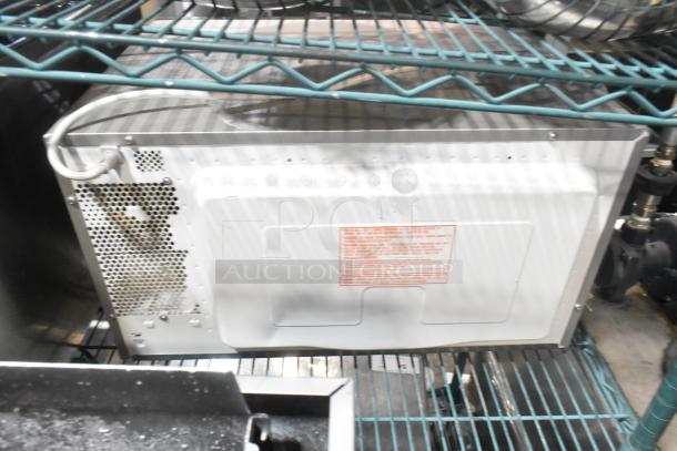 The Genius stainless steel microwave oven, 120 volts, 1 phase, with rear view showing ventilation and electrical cord.