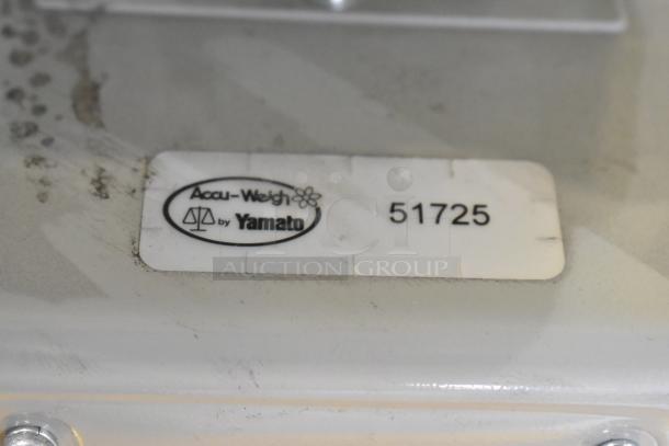 Metal countertop scale with label showing "Accu-Weigh by Yamato" and model number 51725. Signs of wear present.