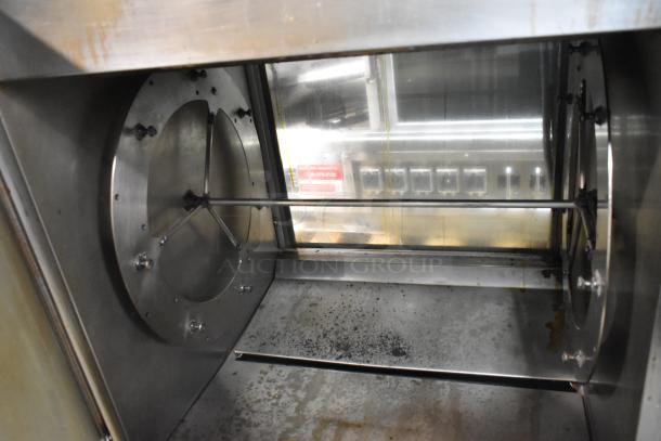 Fri-jado TDR7+7P rotisserie oven interior, showing stainless steel construction and rotisserie mechanism, on casters.