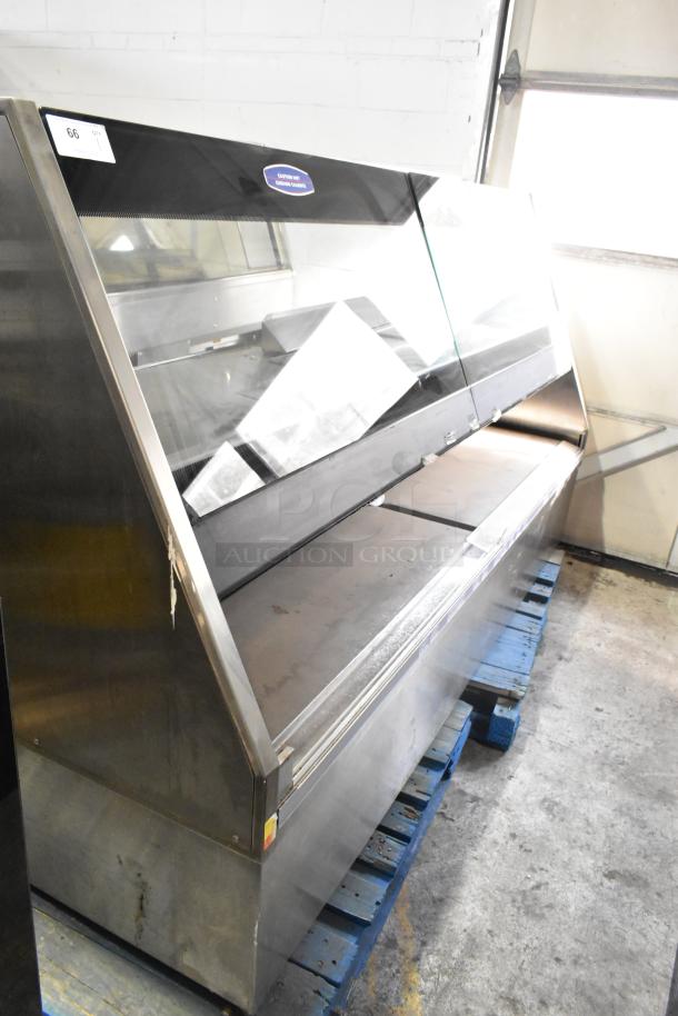 Metal commercial floor-style merchandiser with glass display, built-in lighting, and stainless steel construction; moderate wear.