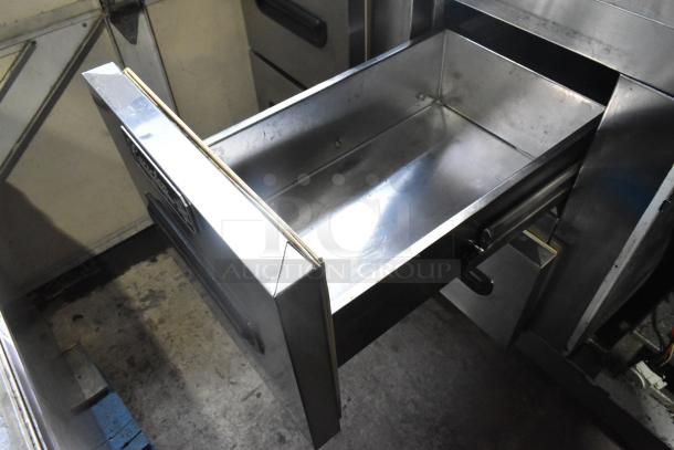 Leader stainless steel 4-drawer undercounter cooler, 115 volts, on commercial casters. Visible brand label.