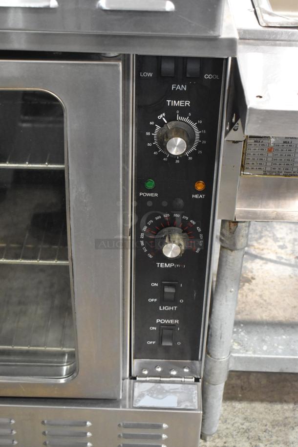 Stainless steel L&J NY convection oven with view-through doors, metal racks, and thermostatic controls on commercial casters.