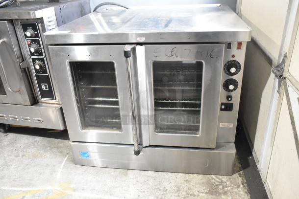 Stainless steel commercial convection oven with thermostatic controls, glass doors, and metal racks. Good condition.