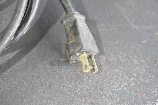 A close-up of a worn power plug associated with the Robot Coupe R2N food processor, showing signs of use.