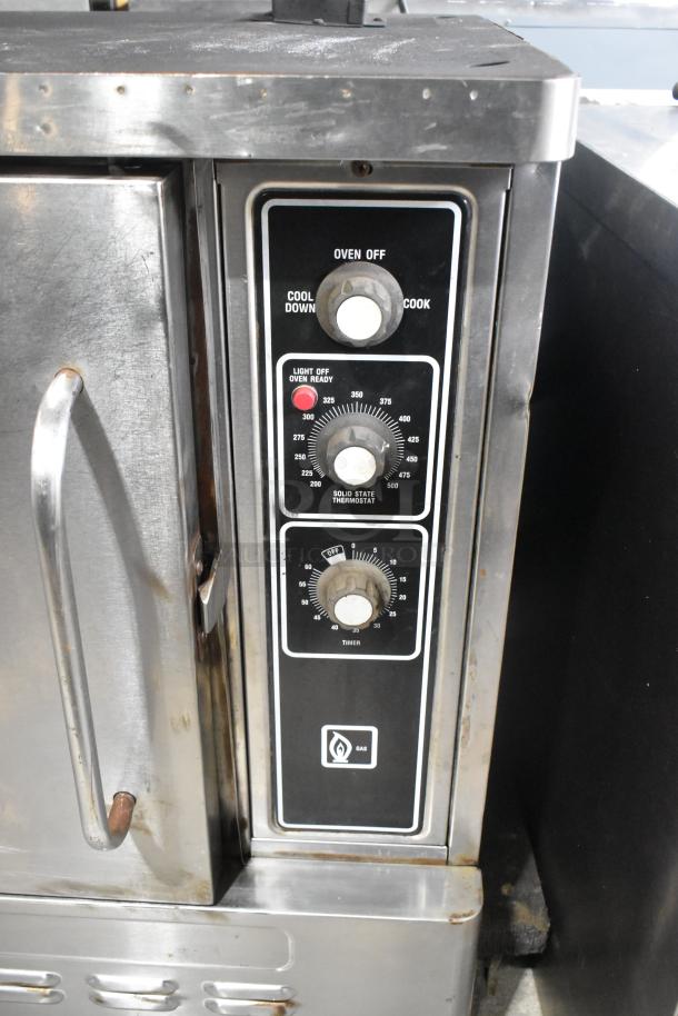 Stainless steel commercial half-size convection oven with view-through door, metal racks, and thermostatic controls visible.
