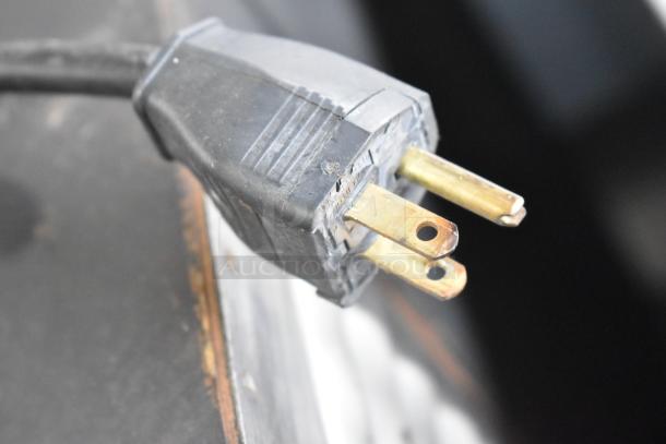 A close-up of a power plug for the Amko AK-60ERC Rice Cooker, 115 volts, showing slight wear.