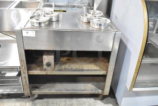 Stainless steel commercial 2 well steam table with cylindrical drop-in bins, showing visible wear and rust on shelves.