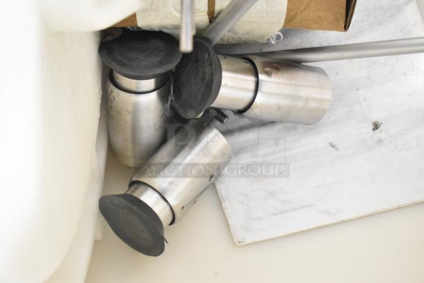 The image shows parts of the 2025 Avantco 194HBN12022 Hotel Ice Dispenser. Includes stainless steel components with black rubber tops.