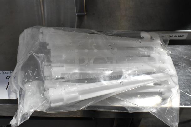 Packaged accessories for VitaMix VM0805B Mix'n Mixer. New, in clear plastic bag, on metal surface.