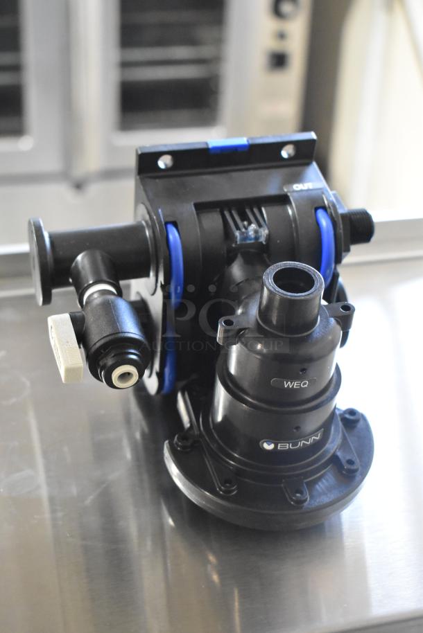 Bunn filter head, brand new with minor scratches, includes fittings, labeled "WEQ" and "Bunn," black with blue accents.