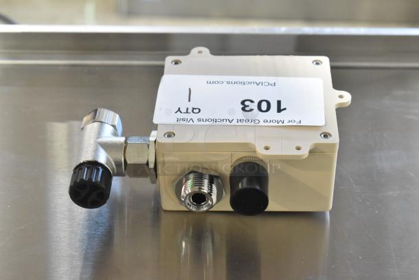 "Brand new scratch and dent box with metal fittings, labeling '103,' and website detail, on a stainless steel surface."