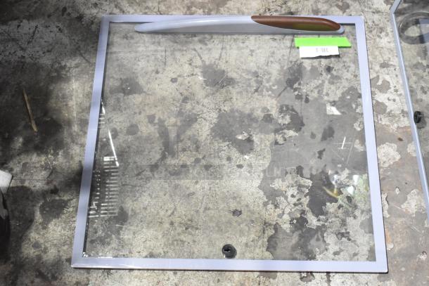 Brand new Avantco 36082323 sliding glass top lid for DFF9 freezer, with intact labels, on a textured floor.