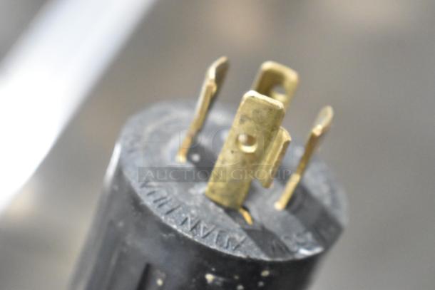 Close-up of the Federal Industries RSSM560SC-5 plug. Metal prongs, 120/208-240V, 1 Phase. For commercial merchandiser.