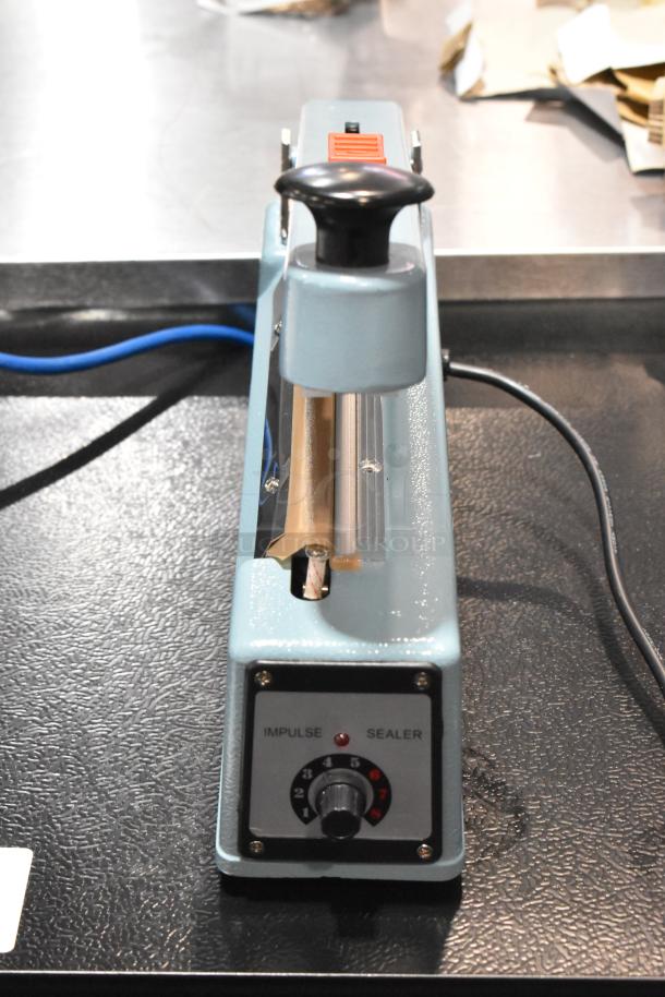 Brand new Hualian FS-200M metal impulse sealer with middle cutter, 110V, 1-phase, in original crate.