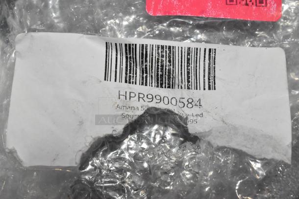 Label on packaging showing barcode and product code HPR9900584 for Amana Lamp-LED, partially obscured by torn bubble wrap.