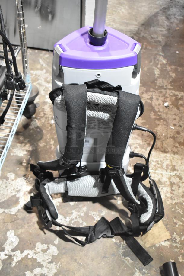 BRAND NEW ProTeam 1076420 Backpack Vacuum Cleaner, scratch and dent, with adjustable padded straps, purple top, and robust build.