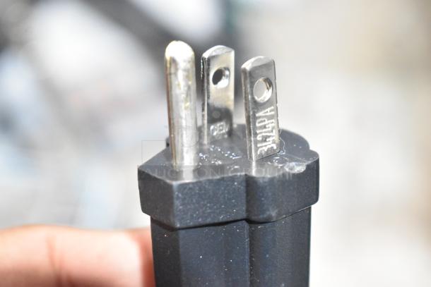 Close-up of a three-prong electrical plug for a Waring WPG250T Panini Grill, showing metal prongs and markings.