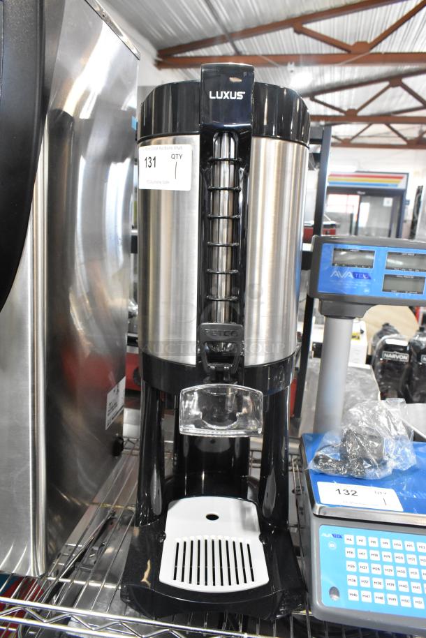 Brand new Fetco LGD-20 Luxus 2 Gallon stainless steel coffee dispenser with stand, minor dents visible, labeled "131".