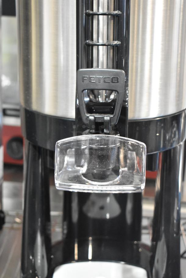 BRAND NEW SCRATCH AND DENT! Fetco LGD-20 Luxus 2 Gallon Stainless Steel Coffee Dispenser with Stand, visible Fetco logo.