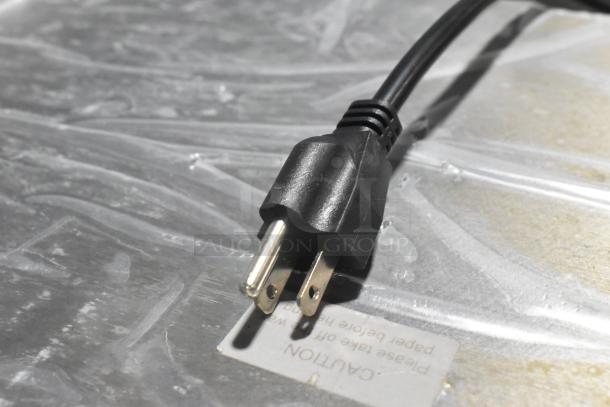 Close-up of electrical plug for Avantco 177RG1830 hot dog roller grill. Label states caution instructions.