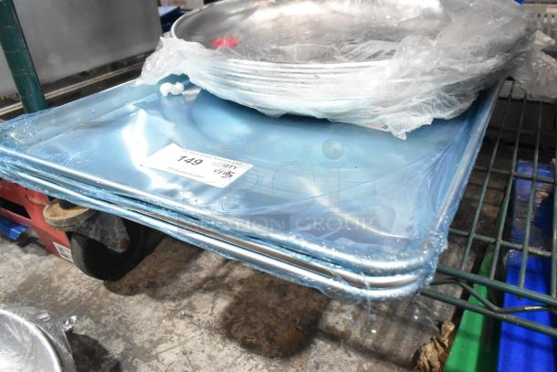 Stack of brand new aluminum trays and pans, various sizes, wrapped in plastic. Auction label shows lot number 149.
