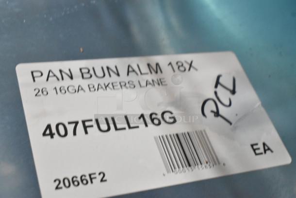 Label on aluminum pan reading "PAN BUN ALM 18X 26 16GA BAKERS LANE 407FULL16G" with barcode and markings.