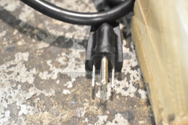 Close-up of a power plug for the Avantco 177CO16 countertop convection oven, with visible three-prong design.