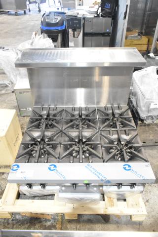 BRAND NEW Garland G36-6T stainless steel 6-burner range, natural gas, with backsplash. Scratch and dent condition, labels visible.