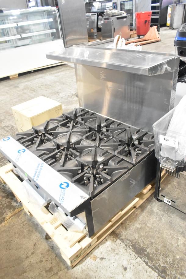 Brand new Garland G36-6T stainless steel commercial 6-burner range. Natural gas powered, with back splash, on pallet.