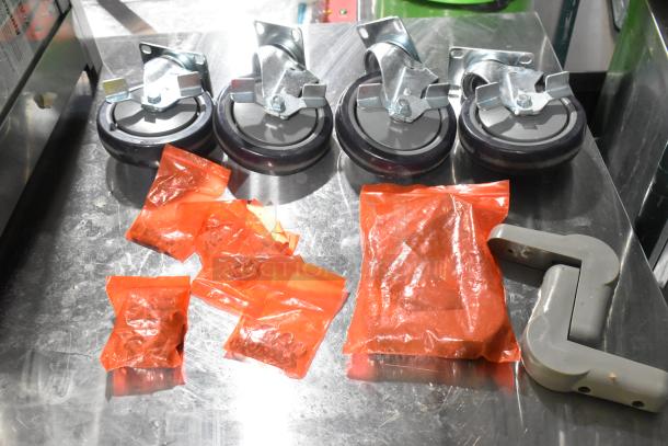 A lot of 4 brand new commercial casters with slight scratches. Includes additional hardware in red plastic bags.