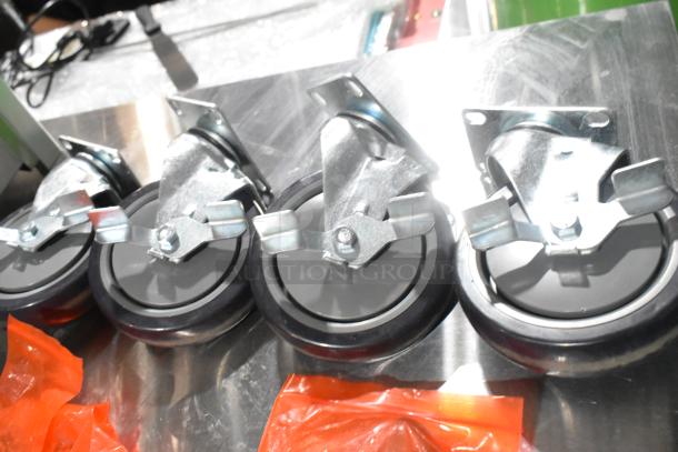 Lot of 4 brand new commercial casters with some scratches. Metal brackets, black wheels, shown in protective packaging.