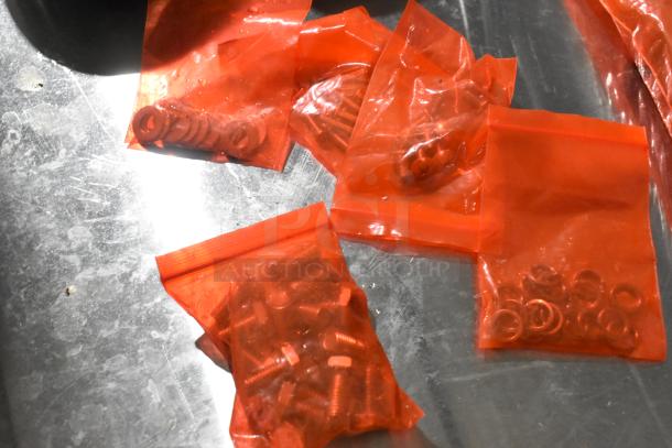 Lot of 4 commercial casters with miscellaneous parts in red bags. Brand new, scratch and dent condition, ideal for industrial use.