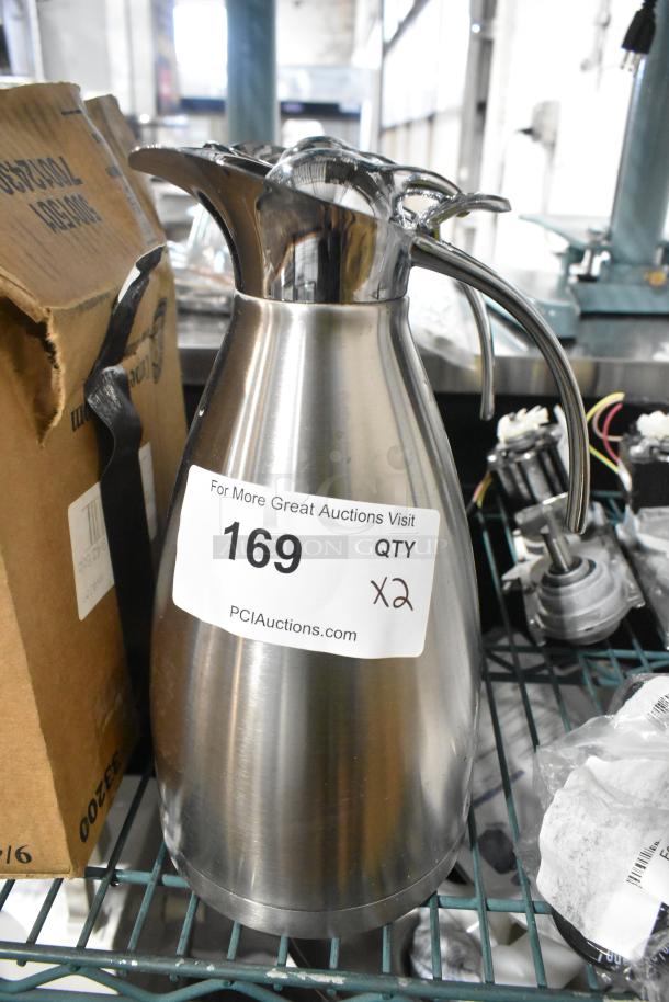 Brand new metal pitcher, stainless steel, minor scratches, dented, auction label indicates "169 QTY x2", PCI Auctions.