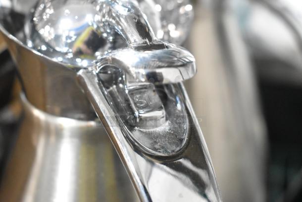 Brand new metal pitcher with minor scratches and dents. Shiny silver finish, ergonomic handle. Great for decorative use.