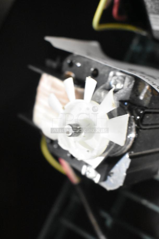 Close-up of a mechanical component with white fan blades on a black base, labeled as "scratch and dent" units. New condition.