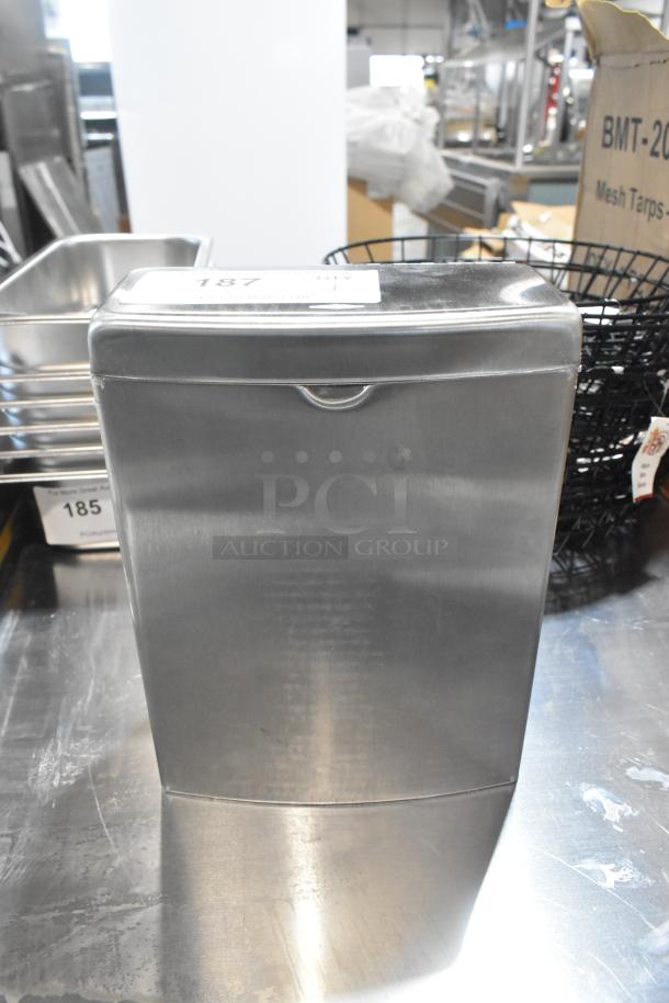 Stainless steel Bobrick bathroom trash can, brand new with minor scratches and dents. Model tag "187" visible on top.