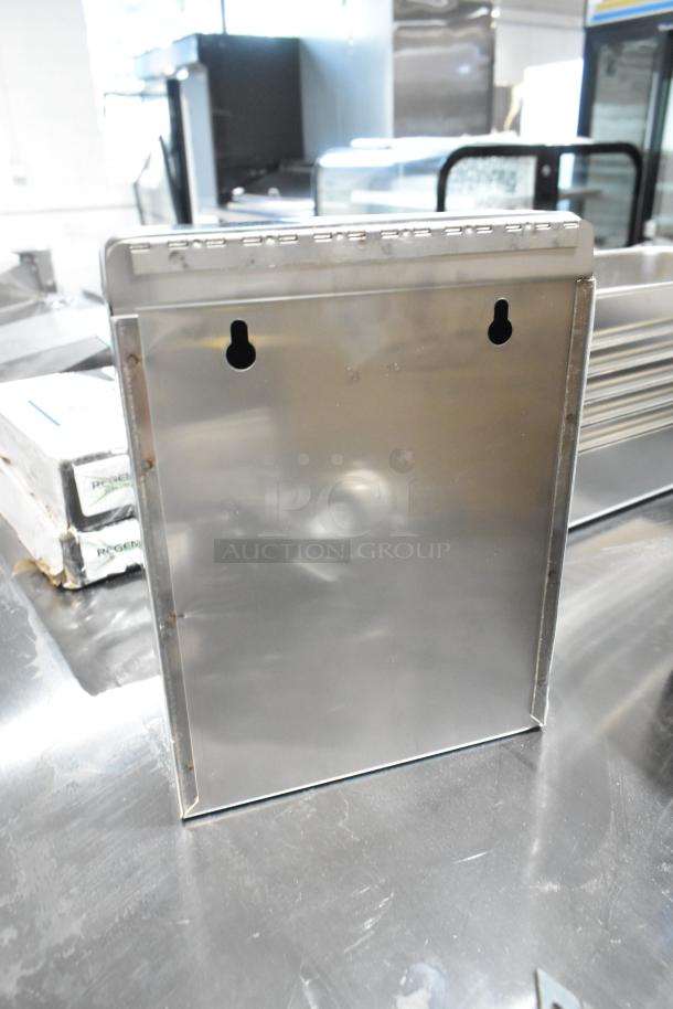 Brand new Bobrick stainless steel bathroom trash can, scratch and dent, wall-mountable, visible keyhole slots.