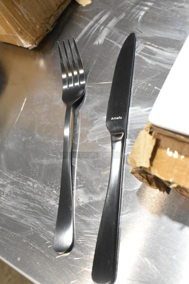 Amefa Austin Black stainless steel table knife and fork on scratched metal surface, brand new condition.