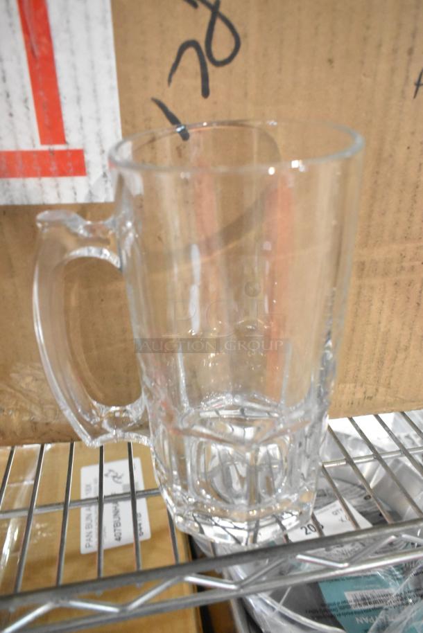 Clear glass mug with handle, shown on a shelf. Part of a new "scratch and dent" auction lot.