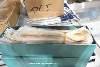 Two brand new boxes of Premium Flatware Sets, slightly scratch and dent, in original packaging, wrapped in plastic.