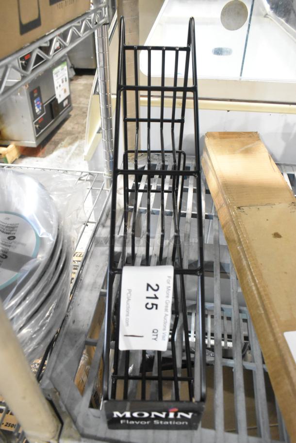 Brand new black metal 4-tier stand with "Monin Flavor Station" label, minor scratches and dents, marked "215" for auction.