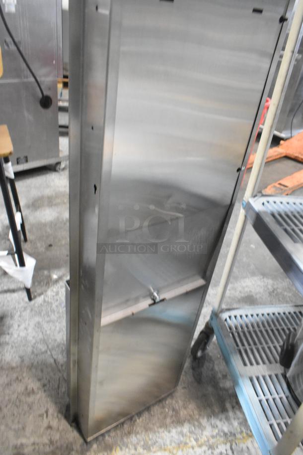 Brand new stainless steel wall mount trash and towel dispenser, visible scratches and dents, vertical design, metal finish.