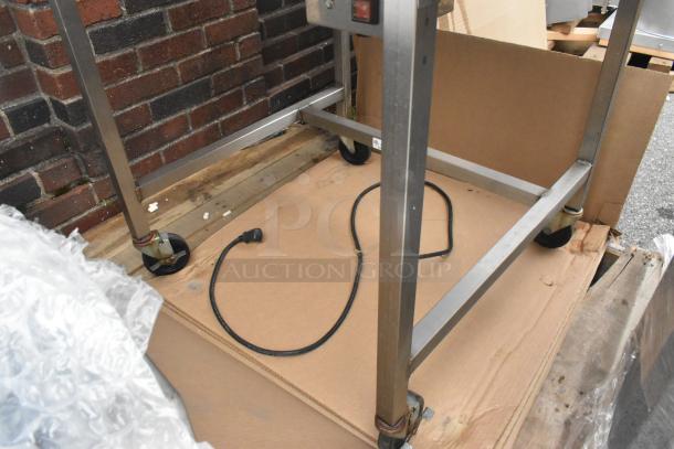 Belshaw H&I-4 stainless steel commercial heat and ice station. Features a 208V, 1-phase power setup. Includes caster wheels and power cord.