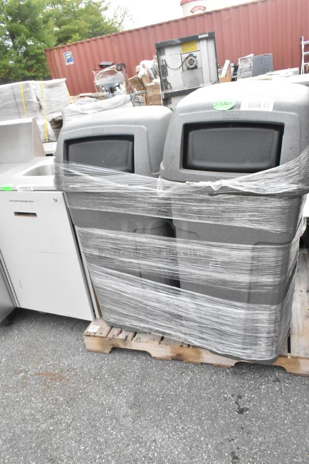 Three gray poly trash cans on a pallet, wrapped in plastic, with visible labels. 