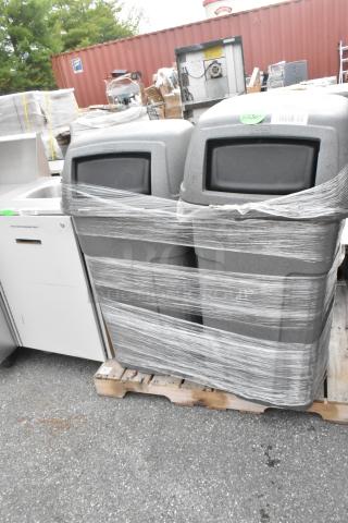 Three gray poly trash cans on a pallet, wrapped in plastic, with visible labels. 