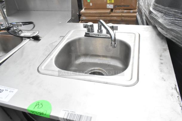 Stainless steel single bay portable sink on commercial casters, featuring a shiny faucet. Green tag with "R5" marking.