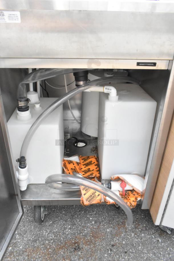 QualServ WMSC24MS stainless steel portable sink on casters. Interior view shows plumbing, tanks, and labels. Commercial use.