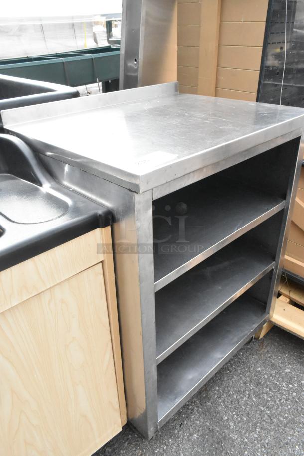 Stainless steel counter with three under shelves, durable construction, clean surface, ideal for kitchen or workshop use.