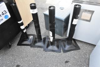 Four brand new 427TBCLRD325 Lancaster outdoor table base columns, black, standard height, labeled with model and tags.